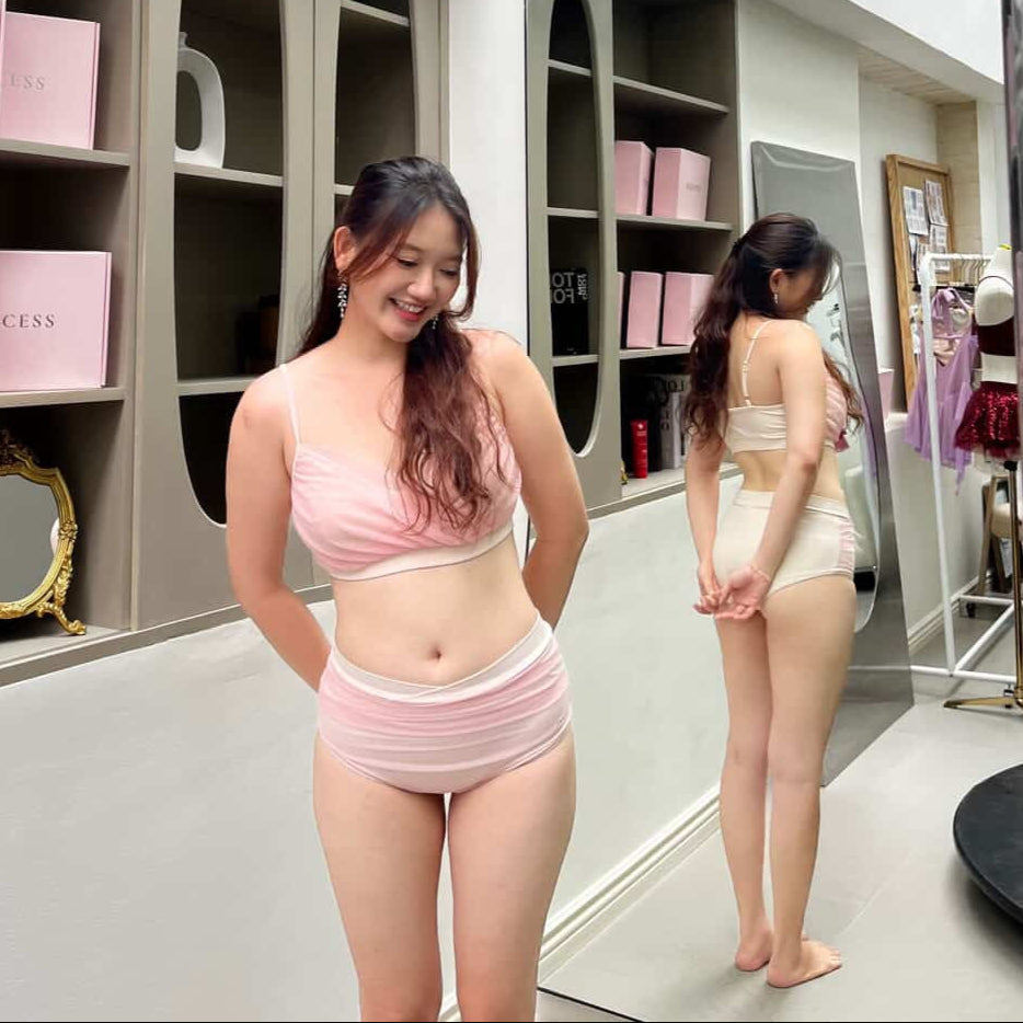 Woman in pink lingerie holding a box in a store setting